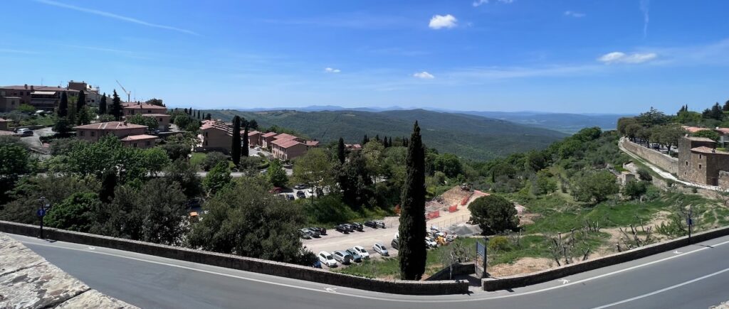 Tuscany Cycling Exploration 7 a road with cars parked in a valley