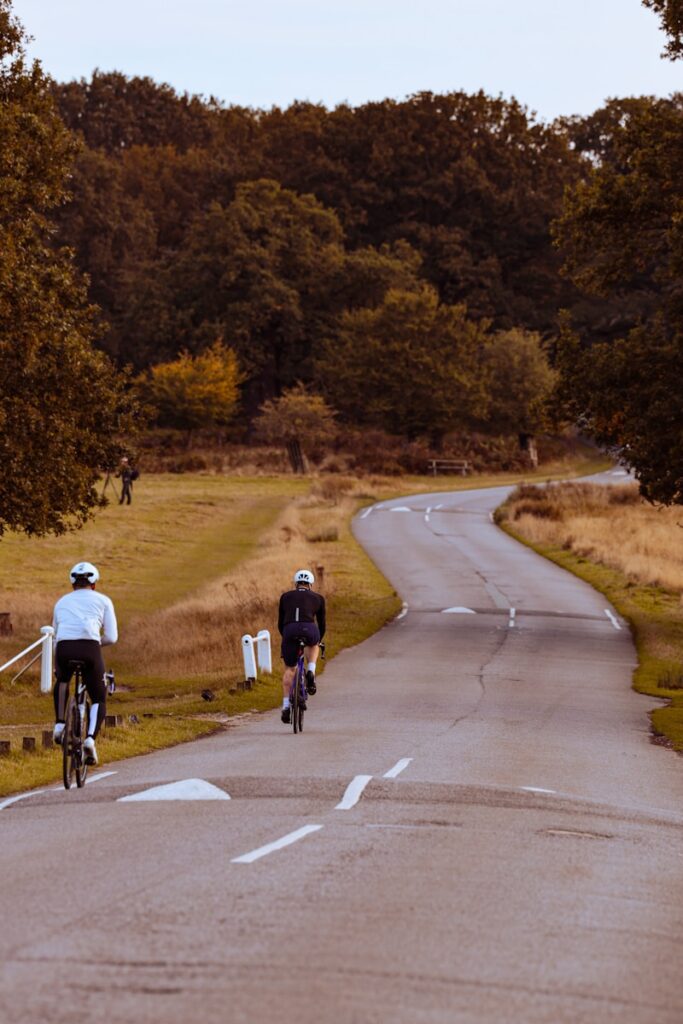 A couple of people riding bikes down a road