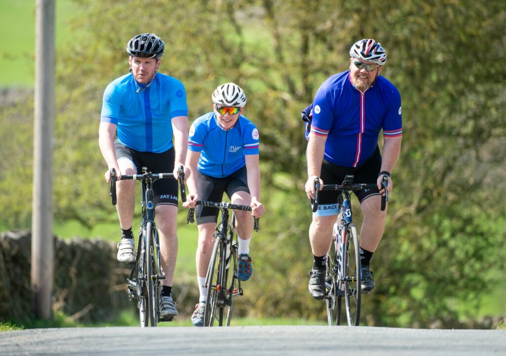 three men riding their bikes down a road