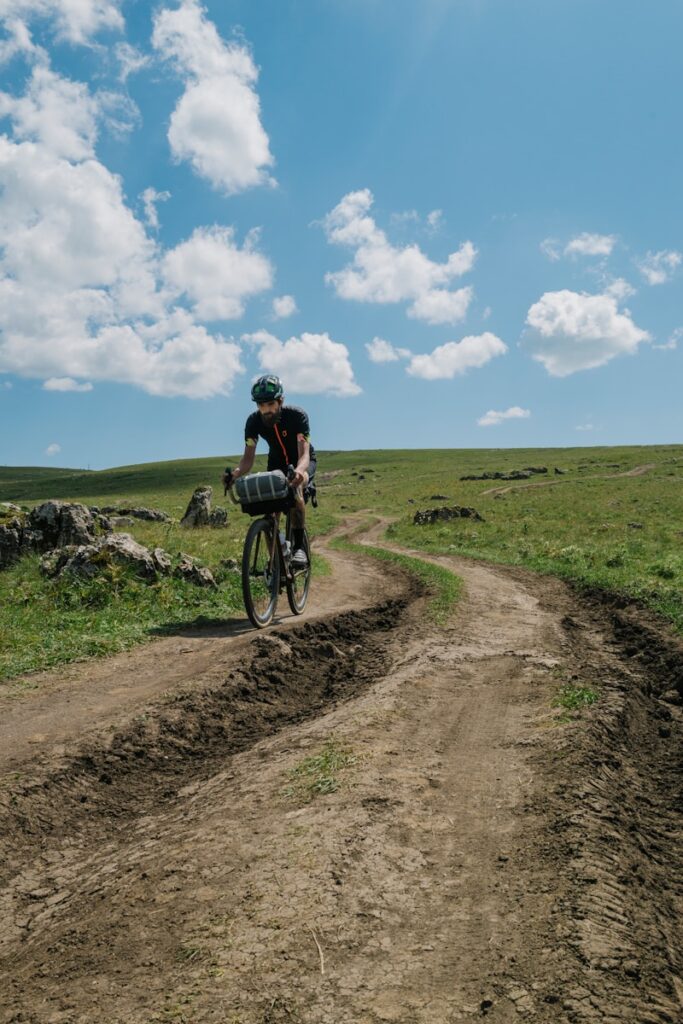 a man riding a bike down a dirt road